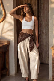 Pantalón de lino, fit balloon, pinzas con cortes frontales, cintura alta con pretina elástica y jareta frontal ajustable, bolsillos delanteros y pinzas en bajo.