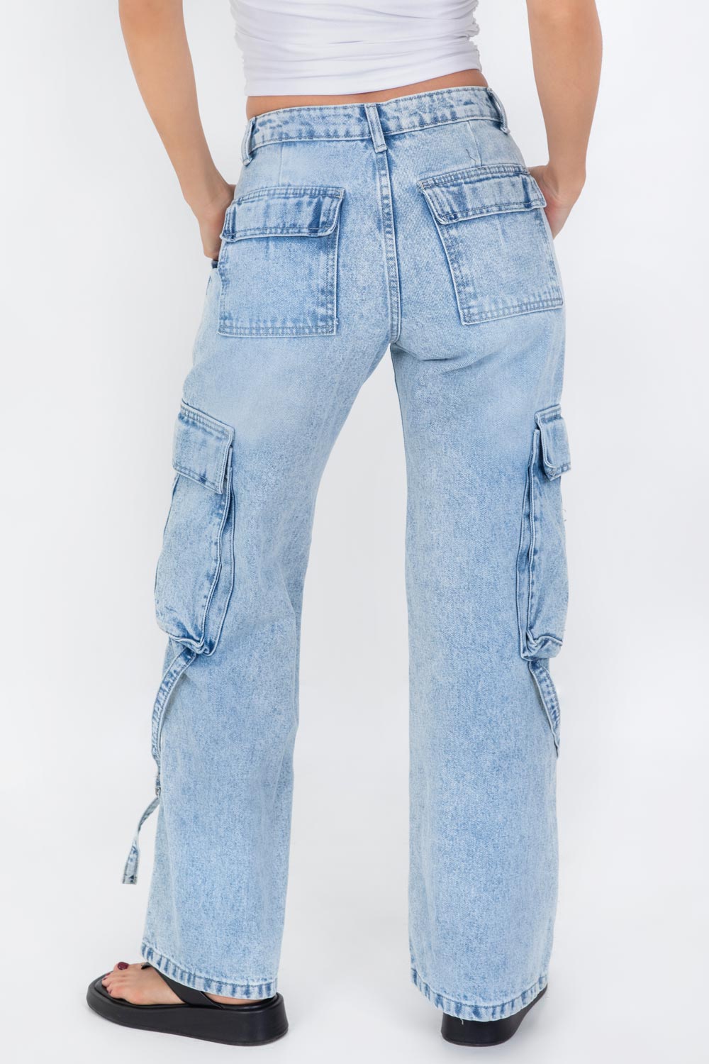 Pantalón cargo de denim, cintura media con pretina y trabillas, de fit recto, bolsillos delanteros de parche, laterales y posteriores cargo con cartera. Detalle de trabillas cruzadas en bajo, cierre frontal con botón y cremallera oculta.