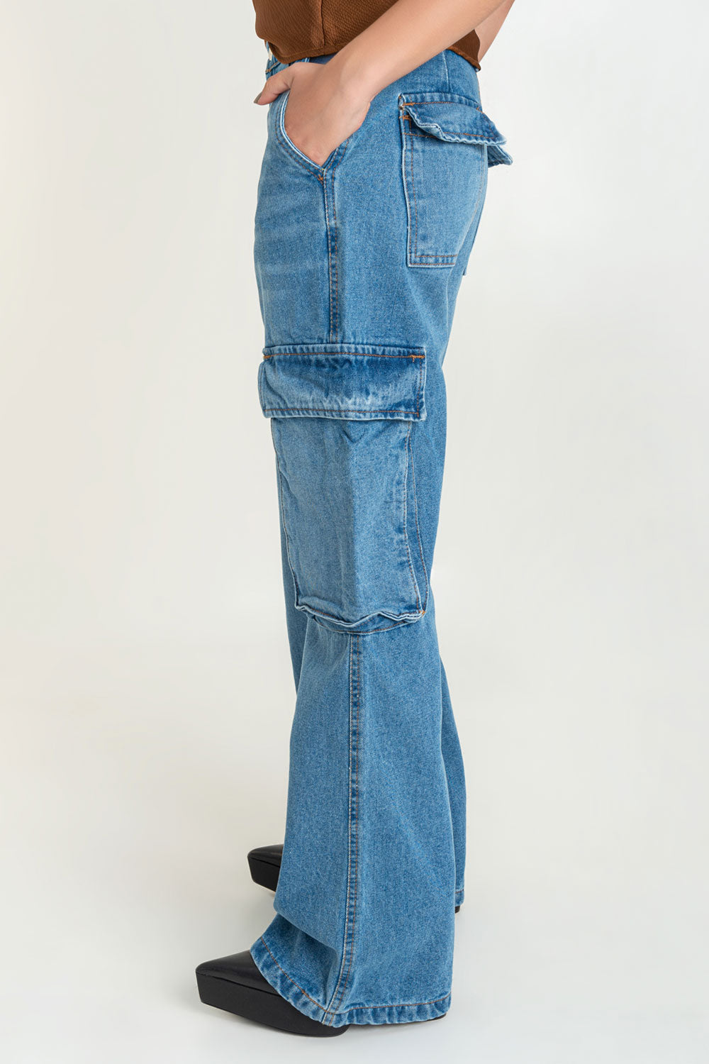Pantalón cargo de denim, fit wide leg de cintura alta con pretina y trabillas, bolsillos delanteros, laterales cargo y traseros de parche con cartera. Cierre frontal con botón y cremallera oculta.