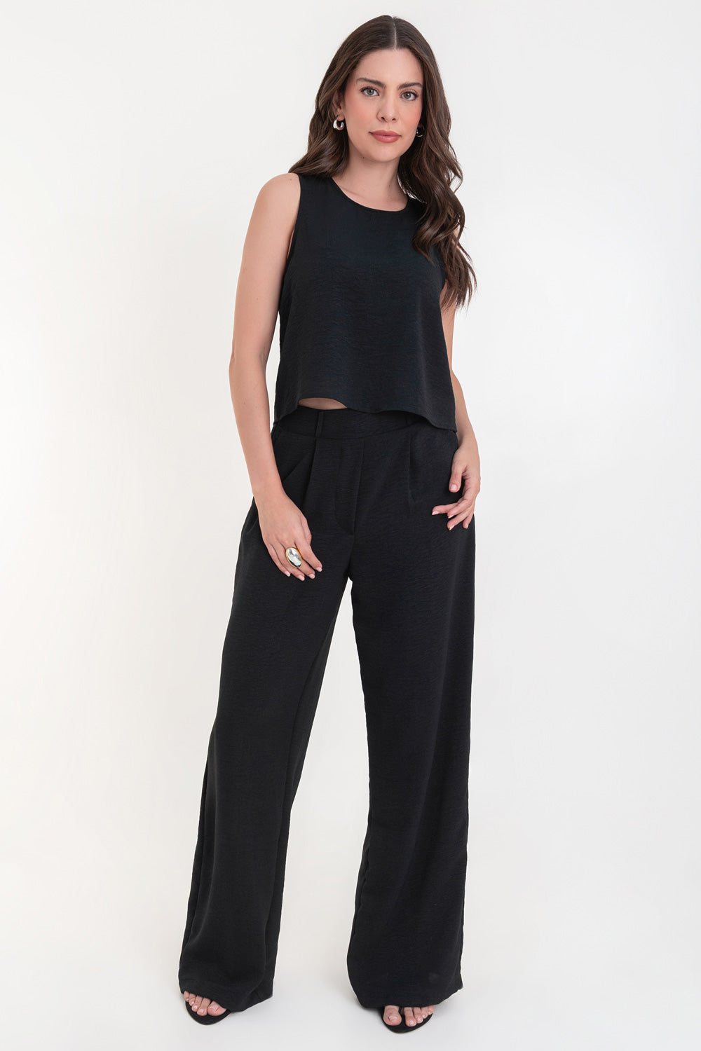 Pantalón de fit palazzo con pierna amplia, pinzas frontales, bolsillos delanteros, cintura alta de pretina con trabillas frontales y elástico posterior.