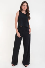 Pantalón de fit palazzo con pierna amplia, pinzas frontales, bolsillos delanteros, cintura alta de pretina con trabillas frontales y elástico posterior.