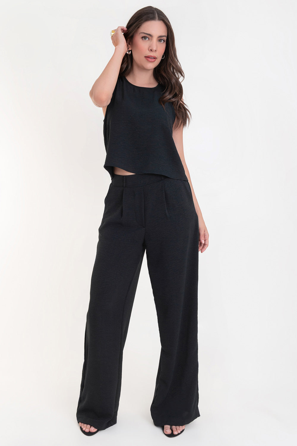 Pantalón de fit palazzo con pierna amplia, pinzas frontales, bolsillos delanteros, cintura alta de pretina con trabillas frontales y elástico posterior.