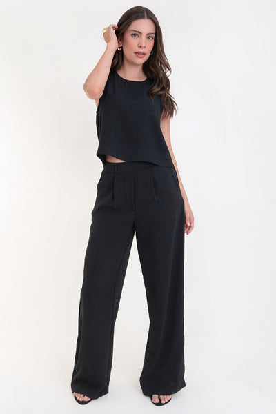 Pantalón de fit palazzo con pierna amplia, pinzas frontales, bolsillos delanteros, cintura alta de pretina con trabillas frontales y elástico posterior.