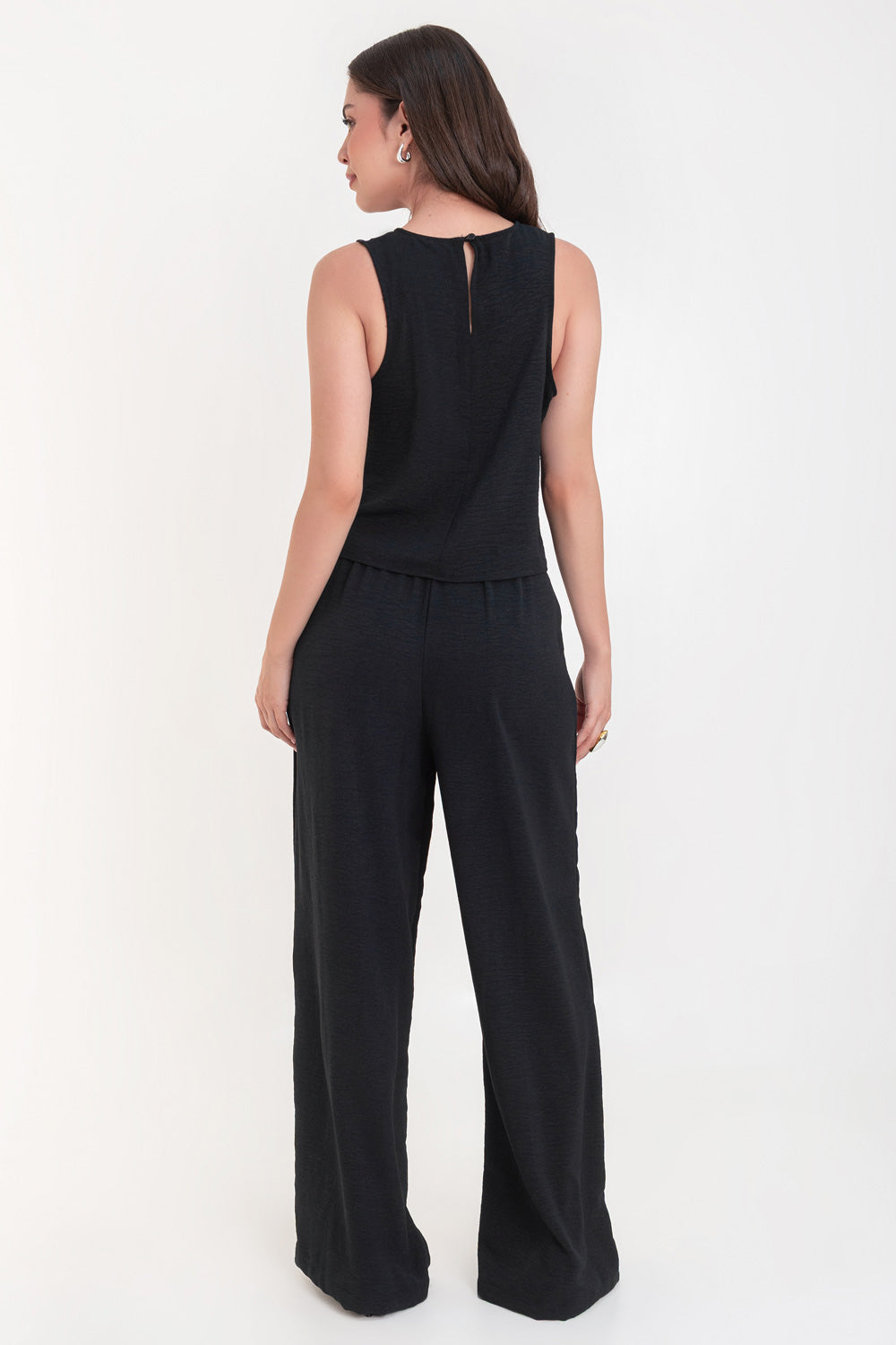 Pantalón de fit palazzo con pierna amplia, pinzas frontales, bolsillos delanteros, cintura alta de pretina con trabillas frontales y elástico posterior.