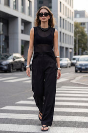 Pantalón de fit wide leg, pinzas frontales, bolsillos delanteros, cintura alta con pretina y trabillas. Detalle de vivo decorativo posterior, cierre con botón y cremallera oculta.