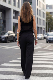 Pantalón de fit wide leg, pinzas frontales, bolsillos delanteros, cintura alta con pretina y trabillas. Detalle de vivo decorativo posterior, cierre con botón y cremallera oculta.