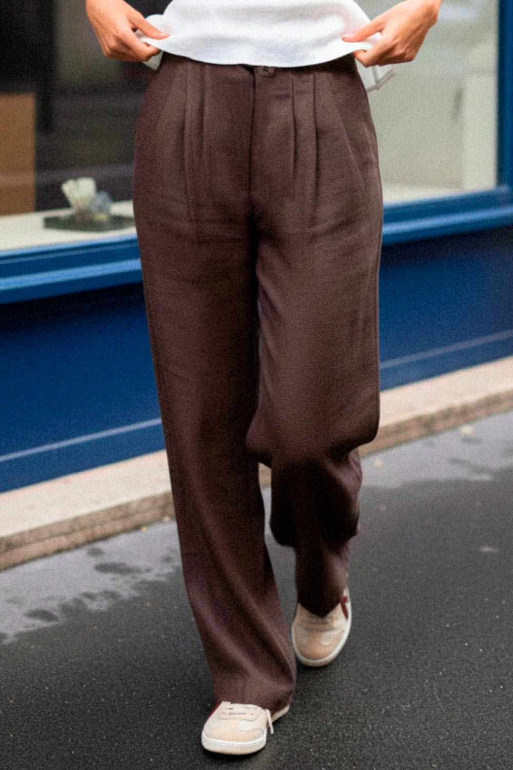 Pantalón fluido de cintura alta con pretina y trabillas, fit wide leg, pinzas frontales, bolsillos delanteros, detalle de raya frontal y posterior. Cierre frontal con botón y cremallera oculta.