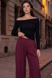 Pantalón fluido de cintura alta con pretina y trabillas, fit wide leg, pinzas frontales, bolsillos delanteros, detalle de raya frontal y posterior. Cierre frontal con botón y cremallera oculta.