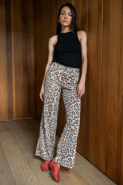 Pantalón de denim, estampado animal, fit wide leg, cintura alta con pretina y trabillas, bolsillos delanteros y traseros de parche. Cierre frontal con botón y cremallera oculta.