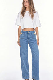 Pantalón de denim, fit cropped flare, cintura alta, bolsillos delanteros con botón y traseros de parche. Cierre frontal con botón en contraste y cremallera oculta.