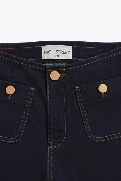 Pantalón de denim, fit cropped flare, cintura alta, bolsillos delanteros con botón y traseros de parche. Cierre frontal con botón en contraste y cremallera oculta.