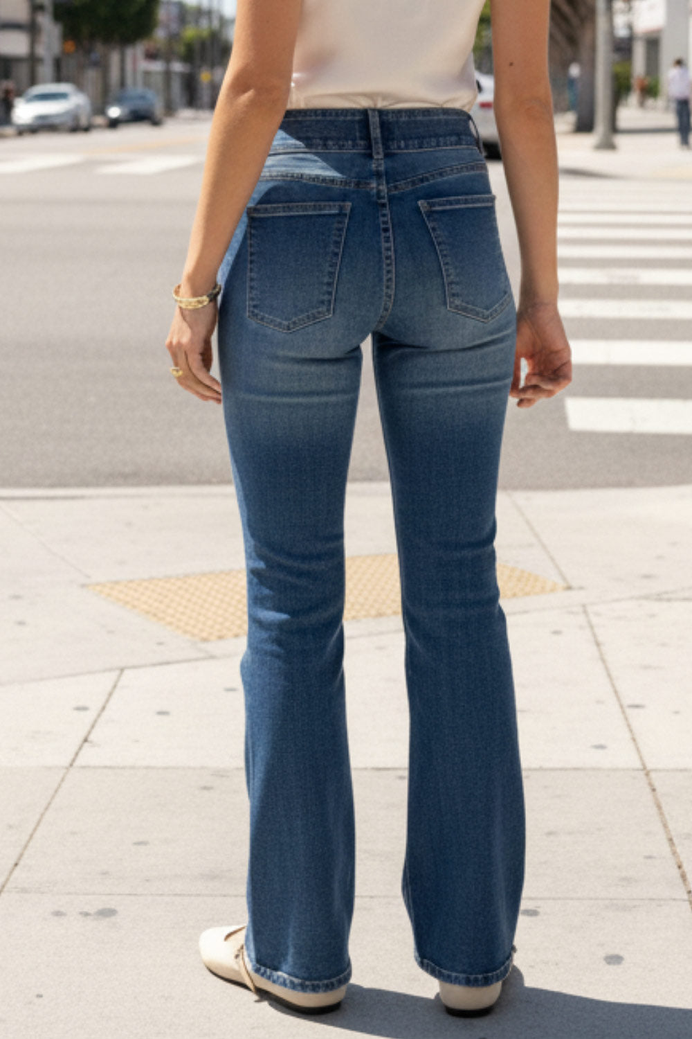 Pantalón ajustado de denim, fit flare, cintura alta con pretina y trabillas, bolsillos delanteros y traseros de parche, detalle de costura frontal decorativa en contraste, cierre frontal con cremallera y botón en contraste.