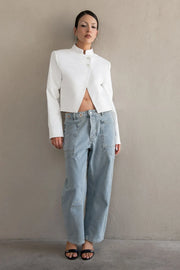 Pantalón de denim, fit barrel, cintura media con pretina y trabillas, bolsillos delanteros y traseros de parche, cierre frontal con botón y cremallera oculta. Detalle de ojillos y costuras decorativas en contraste.
