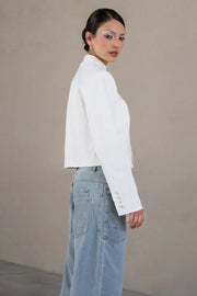 Pantalón de denim, fit barrel, cintura media con pretina y trabillas, bolsillos delanteros y traseros de parche, cierre frontal con botón y cremallera oculta. Detalle de ojillos y costuras decorativas en contraste.
