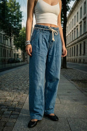 Pantalón de denim, fit wide leg, cintura alta con pretina elástica y trabillas, pinzas frontales, jareta frontal en contraste, bolsillos delanteros y traseros de parche. Cierre frontal con cremallera oculta.