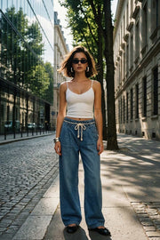 Pantalón de denim, fit wide leg, cintura alta con pretina elástica y trabillas, pinzas frontales, jareta frontal en contraste, bolsillos delanteros y traseros de parche. Cierre frontal con cremallera oculta.