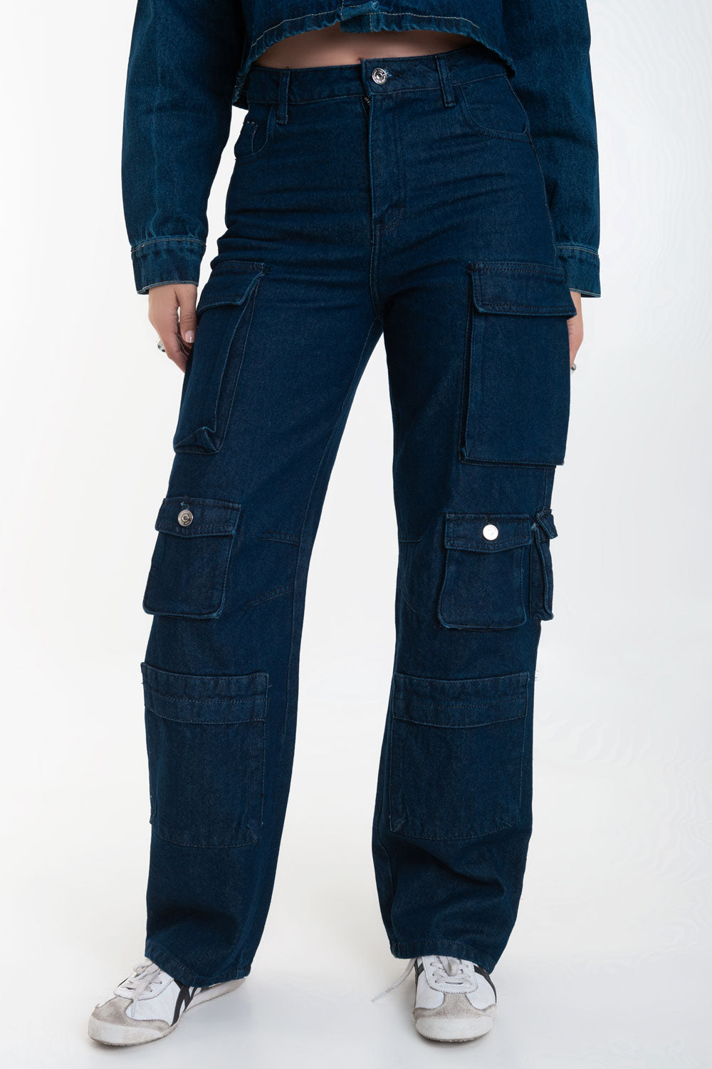Pantalón de denim multipocket, fit recto, cintura alta con pretina y trabillas, bolsillos delanteros, laterales cargo con cartera y traseros decorativos con cartera. Cierre frontal con cremallera y botón en contraste.