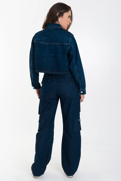 Pantalón de denim multipocket, fit recto, cintura alta con pretina y trabillas, bolsillos delanteros, laterales cargo con cartera y traseros decorativos con cartera. Cierre frontal con cremallera y botón en contraste.