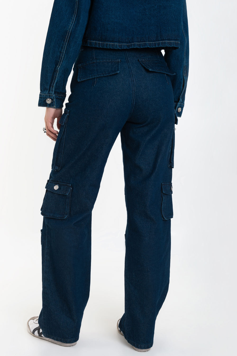 Pantalón de denim multipocket, fit recto, cintura alta con pretina y trabillas, bolsillos delanteros, laterales cargo con cartera y traseros decorativos con cartera. Cierre frontal con cremallera y botón en contraste.