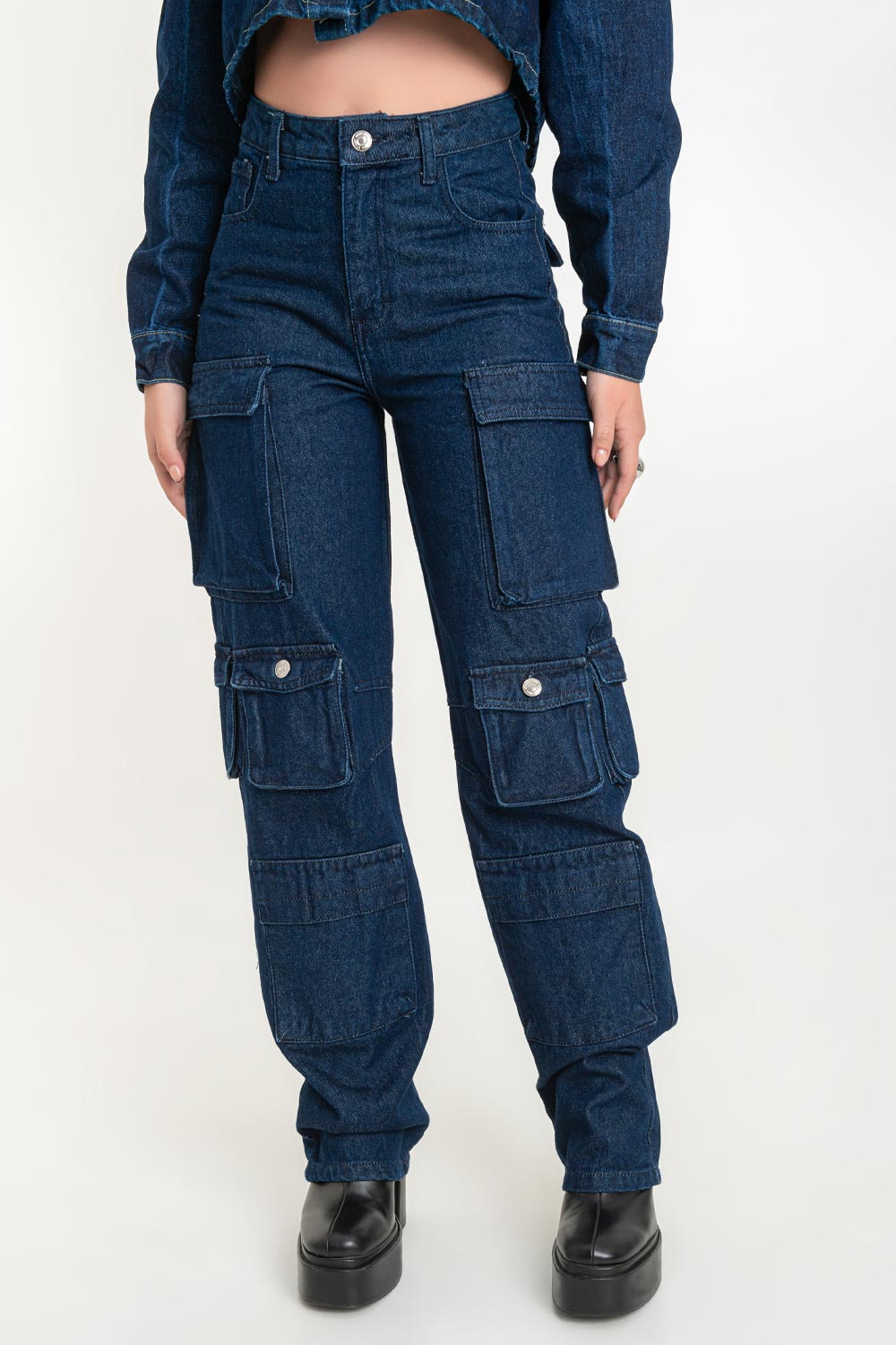 Pantalón de denim multipocket, fit recto, cintura alta con pretina y trabillas, bolsillos delanteros, laterales cargo con cartera y traseros decorativos con cartera. Cierre frontal con cremallera y botón en contraste.