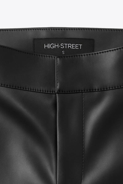 Pantalón de efecto piel, cintura alta con pretina, fit flare, cierre frontal con broche y cremallera ocultos.