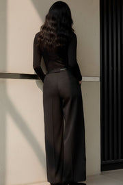 Pantalón de fit wide leg, tiro bajo, pretina con trabillas, pinzas frontales, bolsillos delanteros, detalle de raya frontal y posterior. Cierre frontal con botón y cremallera oculta.