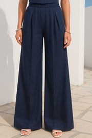 Pantalón de lino, fit palazzo, cintura baja con pretina elástica, bolsillos delanteros y pinzas frontales.