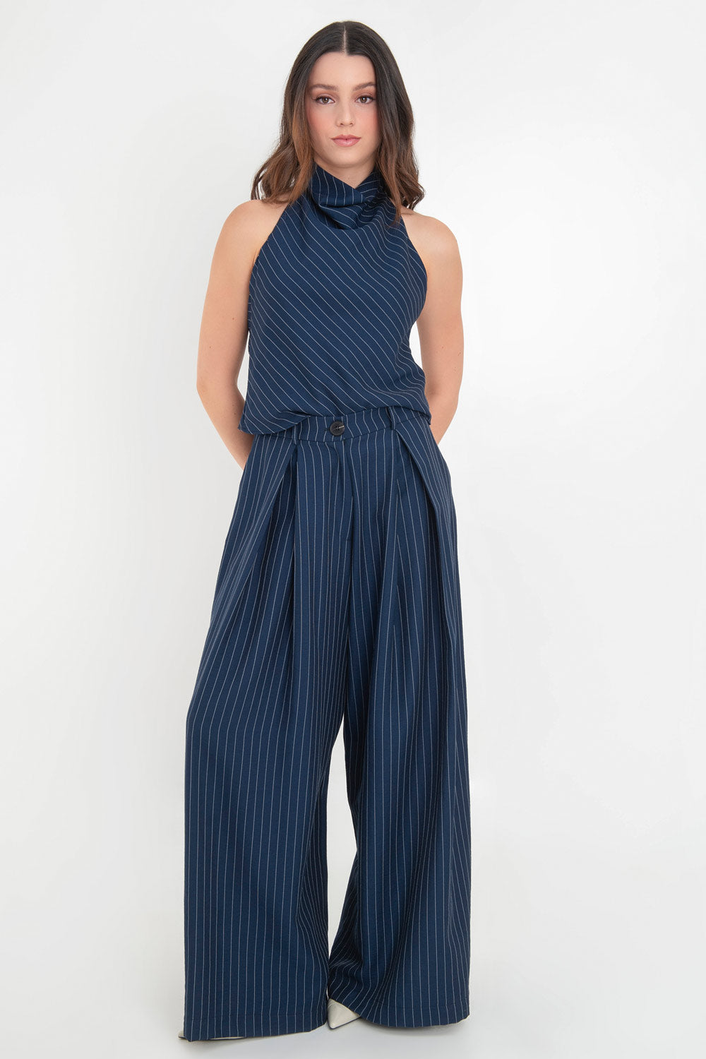 Pantalón de lino, estampado rayas, fit palazzo, cintura alta con pretina elástica posterior, trabillas, bolsillos delanteros y pinzas frontales. Cierre frontal con botón y cremallera oculta.