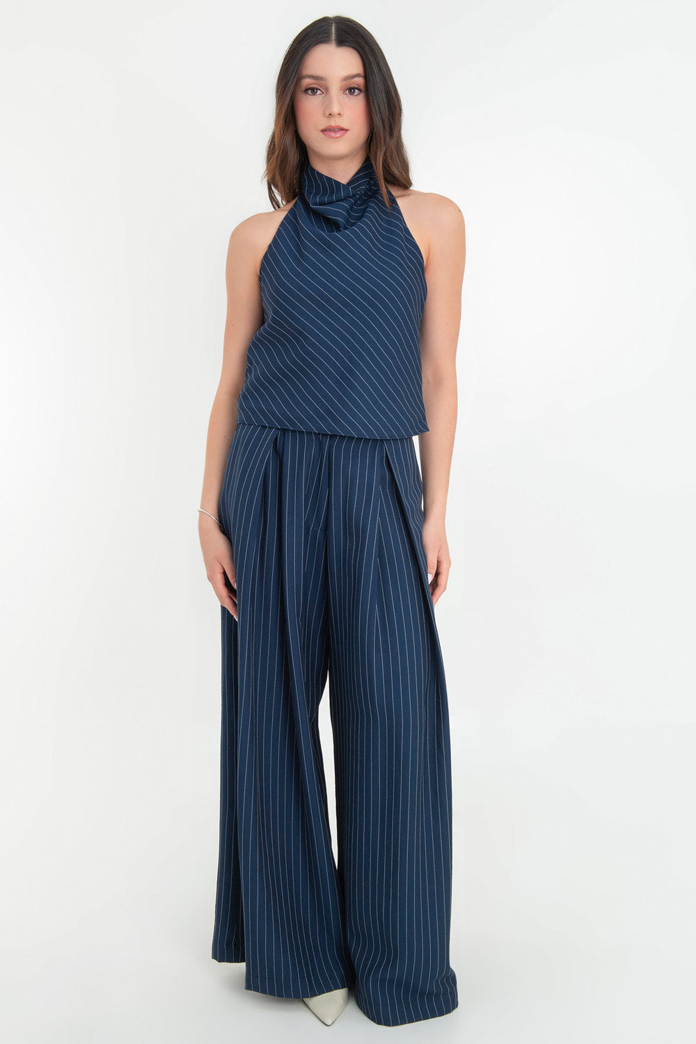 Pantalón de lino, estampado rayas, fit palazzo, cintura alta con pretina elástica posterior, trabillas, bolsillos delanteros y pinzas frontales. Cierre frontal con botón y cremallera oculta.