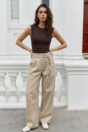 Pantalón de fit wide leg, cintura alta con pretina, trabillas y doble lazo amarrable, pinzas frontales y bolsillos delanteros. Cierre frontal con broche y cremallera ocultos.