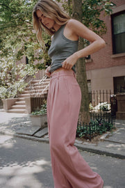 Pantalón de fit wide leg, cintura alta, pretina con detalle v posterior y trabillas, pinzas frontales, bolsillos delanteros y vivos decorativos posteriores. Cierre frontal con botón en contraste y cremallera ocultas.