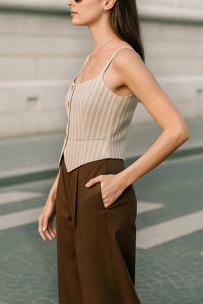 Pantalón de fit wide leg, cintura alta, pretina con detalle v posterior y trabillas, pinzas frontales, bolsillos delanteros y vivos decorativos posteriores. Cierre frontal con botón en contraste y cremallera ocultas.