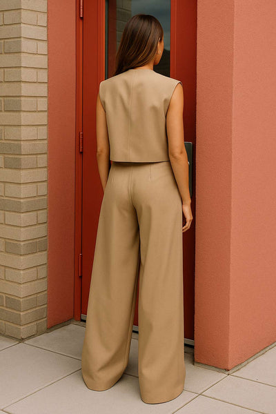 Pantalón de fit wide leg, cintura alta con pretina criss cross, trabillas, pinzas frontales con raya, bolsillos delanteros, cierre frontal con botón en contraste y cremallera oculta.