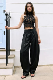 Pantalón satinado de fit balloon, cintura alta con pretina ancha, pinzas con detalle decorativo frontal, bolsillos delanteros, cierre frontal con broche y cremallera ocultos.