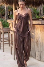 Pantalón de fit balloon, estampado rayas, pinzas con cortes frontales, cintura alta con pretina elástica y jareta frontal ajustable, bolsillos delanteros, pinzas y elástico en bajo.