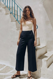 Pantalón de fit culotte, cintura alta con pretina, raya frontal y posterior, bolsillos delanteros y vivos decorativos posteriores. Cierre frontal con broche y cremallera ocultos.