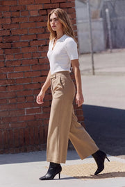 Pantalón de fit culotte, cintura alta con pretina, raya frontal y posterior, bolsillos delanteros y vivos decorativos posteriores. Cierre frontal con broche y cremallera ocultos.
