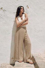 Pantalón de fit wide leg, pinzas frontales, cintura alta con pretina y cruce frontal decorativo. Cierre lateral con cremallera oculta.