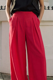 Pantalón de fit palazzo, cintura alta, bolsillos delanteros, pinzas frontales y cierre posterior con cremallera oculta.