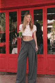 Pantalón de estampado rayas, fit palazzo, cintura alta, pretina con solapa y lazo amarrable frontal, pinzas frontales con detalles decorativos y bolsillos delanteros. Cierre frontal con botón y cremallera oculta.