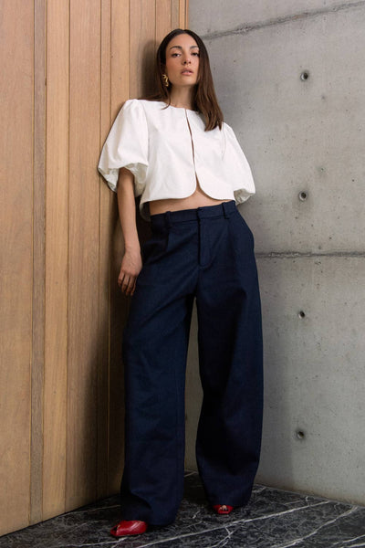Pantalón de fit recto, cintura media con pretina y trabillas, bolsillos delanteros y vivos decorativos posteriores. Detalles de pinzas frontales, cierre con broche y cremallera ocultos.