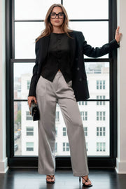 Pantalón de fit recto, cintura alta con pretina y trabillas, bolsillos delanteros y posteriores decorativos con cartera, raya frontal, cierre con broche y cremallera ocultos.