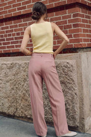 Pantalón de fit wide leg, cintura alta con pretina y trabillas, pinzas frontales con raya frontal, bolsillos delanteros, vivo decorativo posterior, cierre frontal con broche y cremallera ocultos.