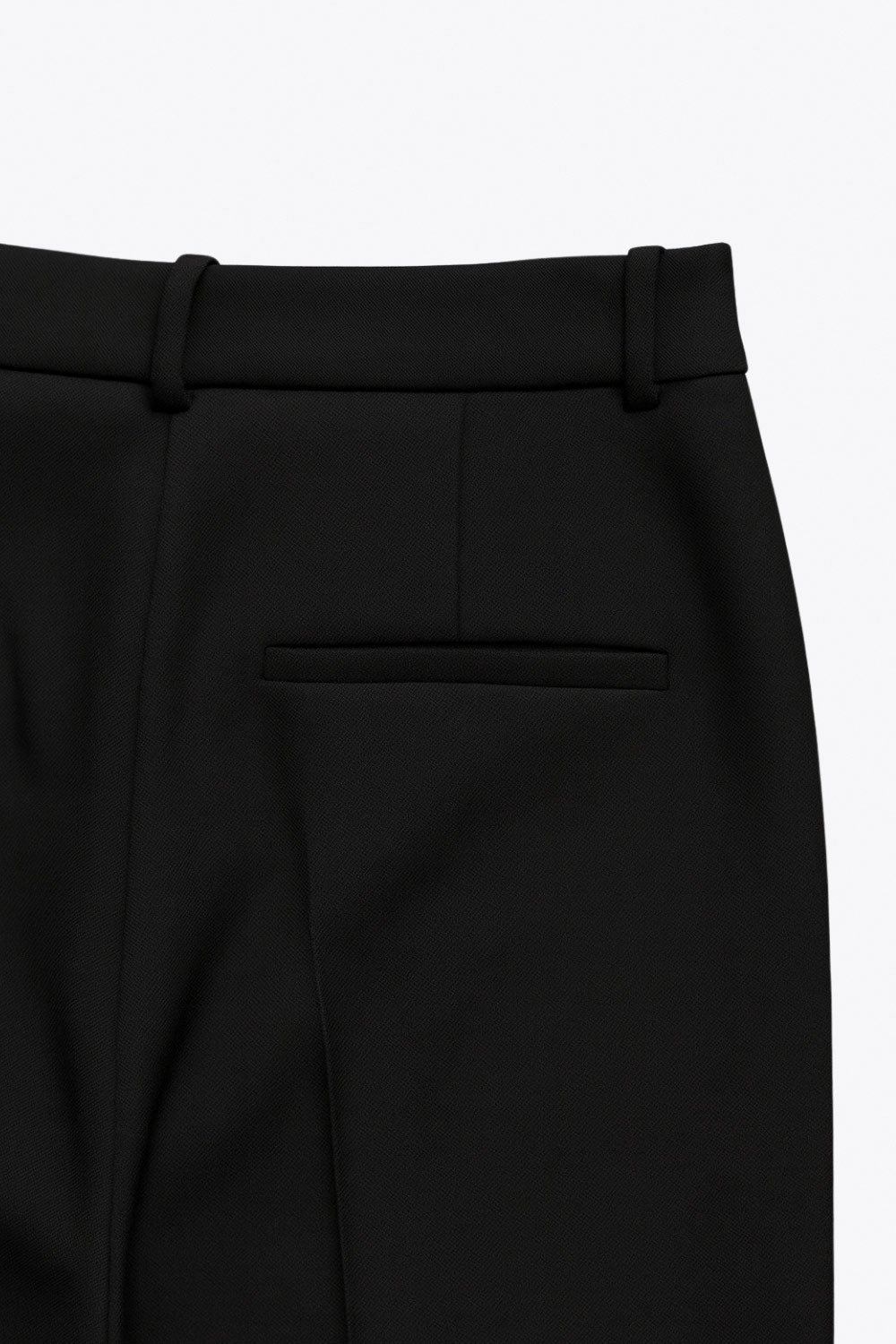 Pantalón de fit wide leg, cintura alta con pretina y trabillas, pinzas frontales con raya frontal, bolsillos delanteros, vivo decorativo posterior, cierre frontal con broche y cremallera ocultos.