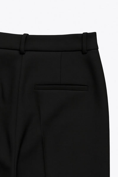 Pantalón de fit wide leg, cintura alta con pretina y trabillas, pinzas frontales con raya frontal, bolsillos delanteros, vivo decorativo posterior, cierre frontal con broche y cremallera ocultos.