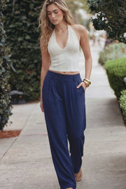 Pantalón fluido de fit wide leg, cintura alta con pretina elástica posterior, trabillas, pinzas frontales y bolsillos delanteros.