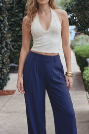 Pantalón fluido de fit wide leg, cintura alta con pretina elástica posterior, trabillas, pinzas frontales y bolsillos delanteros.