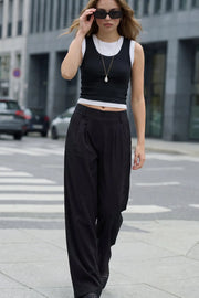 Pantalón fluido de fit wide leg, cintura alta con pretina elástica posterior, trabillas, pinzas frontales y bolsillos delanteros.