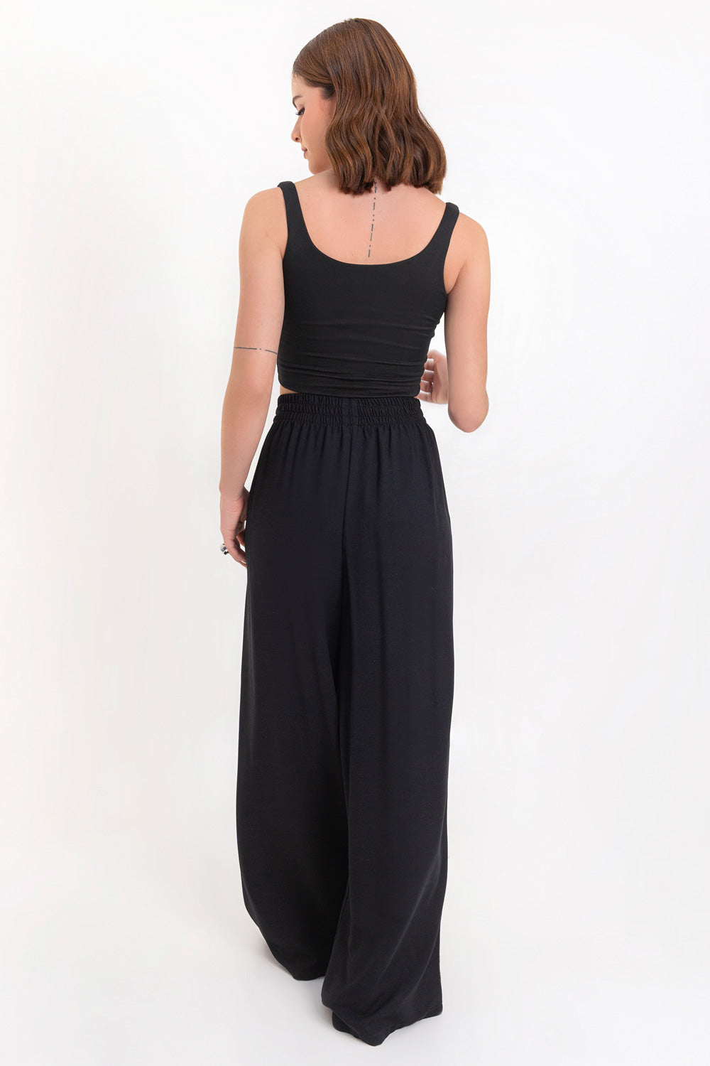 Pantalón fluido de fit wide leg, cintura alta con pretina elástica y bolsillos delanteros.