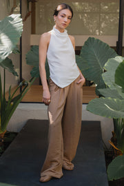 Pantalón fluido de fit recto, con pinzas frontales, cintura alta con pretina elástica posterior, bolsillos delanteros, cierre frontal con botón y cremallera oculta.